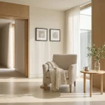 Armstoel met gebreide plaid in minimalistische verpleeghuislounge, bijzettafel met thee, ochtendlicht en lichte houtpanelen