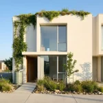 Moderne minimalistische townhouse met groen dak, verticale tuin, regenton en regentuin, in helder ochtendlicht
