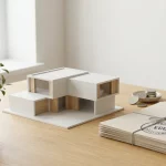 Eco-vriendelijk modern huismodel op houten bureau naast documenten met stempel en euromunten, met klein plantje in daglicht
