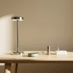 LED-lamp en slimme thermostaat op minimalistische houten tafel, kabel naar stekkerblok met muntstapel voor snelle terugverdientijd
