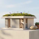 Minimalistisch modern huismodel met groen dak, vogelhuisje en insectenhotel op beton, ochtendlicht en veel negatieve ruimte