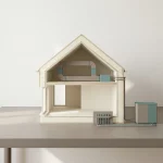 Minimalistisch doorsnedemodel van modern huis met isolatie, ventilatie met WTW, vloerverwarming en warmtepomp op tafel